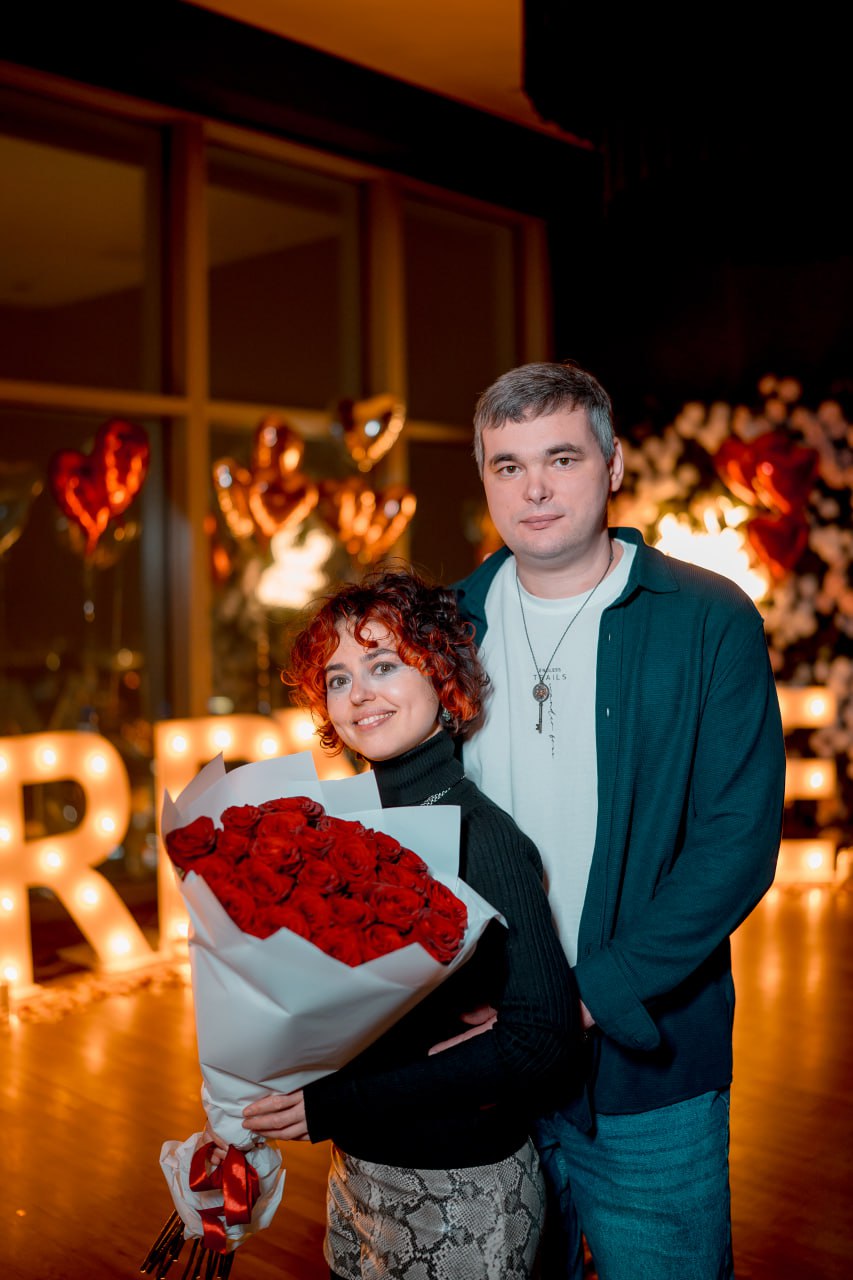 Мы вдвоём — фотография в тёплом свете свечей, на фоне светящихся букв MARRY ME